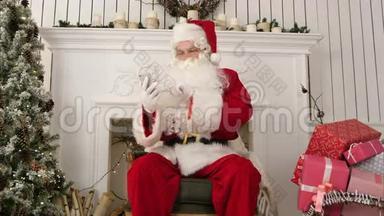 圣诞老人在他的电话里查看孩子们发来的圣诞电子邮件